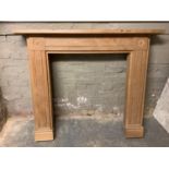 A modern oak fire surround of simple classical design, 140cm wide x 117cm high, the aperture 62cm