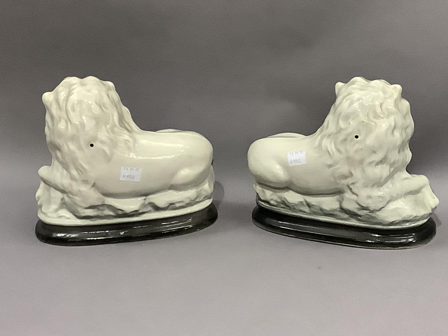 A pair of pottery lions, sponged in dark grey and highlighted in gilt - Image 2 of 2
