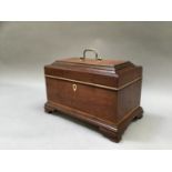 A Georgian mahogany tea caddy having a gilded brass handle to the lid, lacking fittings and on