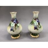 A pair of Royal Worcester vases of ovoid form painted with purple and white violets on a circular
