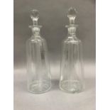 A pair of decanters of tapered cylindrical form with facetted stoppers etched and cut with