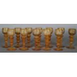 A set of twelve 19th century German amber hock glasses, the cup-shaped bowls etched with hunting