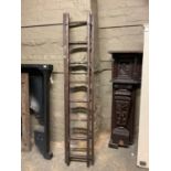 A pair of vintage stained pine extending ladders