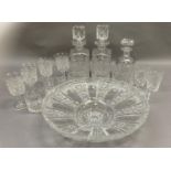 A heavily cut glass fruit bowl of circular outline, a pair of cut glass spirit decanters and a set