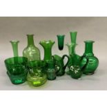 A quantity of Victorian and later green glass including bottle decanters, cream jug, specimen vases,