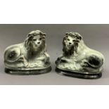 A pair of pottery lions, sponged in dark grey and highlighted in gilt