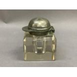 A glass inkwell with metal jockey cap shaped lid 7cm high