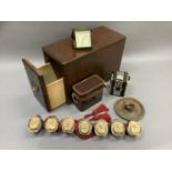 An oak filing box containing a box camera, travel clock, leather case and a wall hanging row of