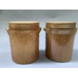 A pair of early 20th century salt glaze cylindrical storage jars and covers having twin moulded