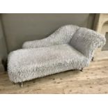 A modern day bed with shaggy oatmeal coloured upholstery on short cabriole legs of silver coloured