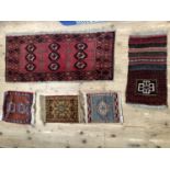 A small Bokhara rug of maroon ground of 109cm x 48cm approx, together with four small rug panels