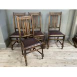 A set of four rail back oak dining chairs with upholstered seats