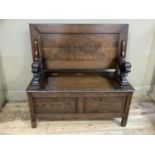 An oak monk's bench with carved panel front, (faults to the pins for the sliding top)