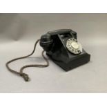 A black Bakolite telephone, the underside stamped L11568 31 312F H55/3A with original corded wire