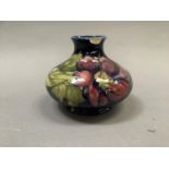 A Moorcroft 'clematis' vase of compressed circular form painted and tube lined in shades of mauve,