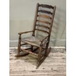 A Victorian elm rush seated rocking chair with ladder back