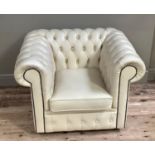 A cream buttoned leather Chesterfield armchair, ensuite with the preceding lot, (one button missing)