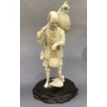 A Tokyo School ivory carving of a fisherman holding a basket of fish, nets and hat over his