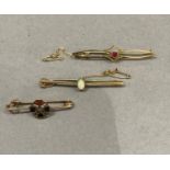 Three Victorian and Edward VII bar brooches all in 9ct gold including a collet set garnet flanked by