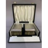 A pair of Elizabeth II gentleman's silver engine turned back hair brushes, in fitted case,