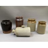 Four pottery and earthenware storage jars, one of salt glaze, together with a stone hot water bottle