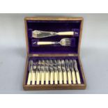 An early 20th century oak canteen of twelve EPNS and ivorine handled fish knives and forks and