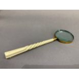 An early 20th century magnifying glass with long carved ivory handle, 36cm long