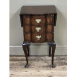 A mahogany serpentine fronted bedside cabinet of three drawers with brass swing handles, drop leaves