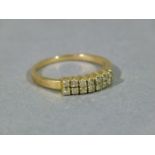 A diamond set half hoop ring, the brilliant cut stones claw set in parallel lines in yellow metal (