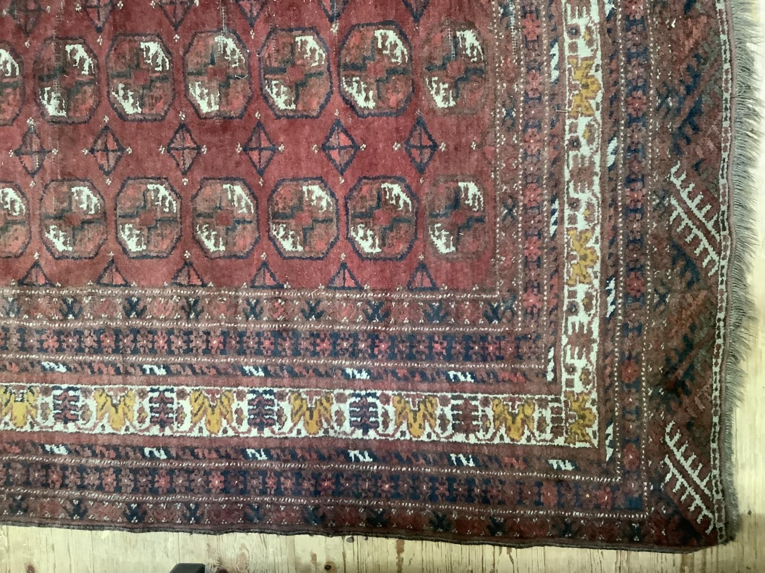 A Bokhara rug of crimson ground with four rows of elephant feet medallions within multiple - Image 3 of 4