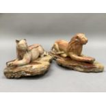 A carved onyx lion and lioness each resting on a plinth of onyx, 11cm and 10cm high, plinths 24.