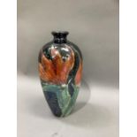 A Lise B Moorcroft vase, tube lined and painted in flame orange and green with a flower against a