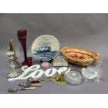 A large maroon glass flute with faux berries, a Rouen candlestick, a blue and white charger, glass