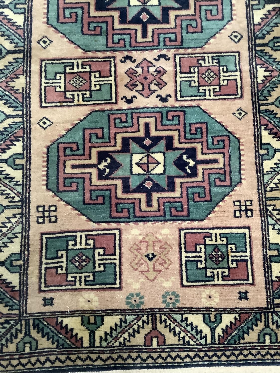 A small Middle Eastern style rug the mushroom ground having two green, mauve and navy blue octagonal - Image 2 of 2