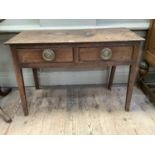 An oak side table with two drawers to the apron with brass rosette and ring handles on square