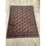 A salmon and ivory and dark blue Bokhara rug measuring 170cm x 128cm