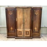 An Edwardian mahogany breakfront four door wardrobe inlaid in satinwood with ribbon swags, fluting