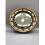 A gilt framed convex wall mirror with black reeded slip and spherical mounts to the frame, 49cm