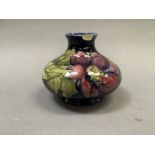 A Moorcroft 'clematis' vase of compressed circular form painted and tube lined in shades of mauve,