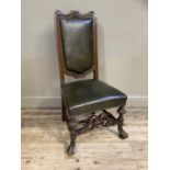 A walnut framed and close nailed hide upholstered single chair, carved front stretcher with braganza