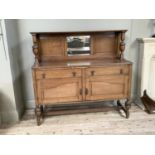 1930s oak sideboard having a raised back with inset bevelled mirror, lobed and turned uprights,