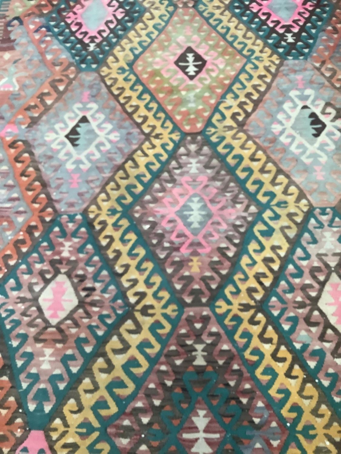 A large kelim rug of three rows of hooked diamond medallions in shades of pink, yellow, green, fox - Image 3 of 3