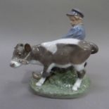 A Royal Copenhagen figure of a Dutch boy with calf, 17cm high (slight chip to calf's ear)