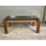 A 1970's teak and smoked glass topped coffee table, 106cm long by 58cm wide