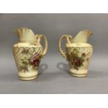 A pair of Royal Worcester blush ivory ewers having a wrythern fluted and moulded lip and
