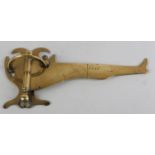 A 19TH CENTURY BRASS SWING WALL ARM in the form of a booted leg, the plate of shield shape, arm 23cm