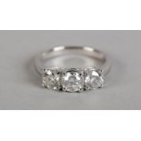 A THREE STONE DIAMOND RING in 18ct white gold, the brilliant cut stones claw set in line, total