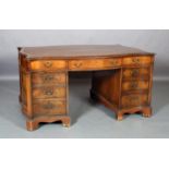 A GEORGE III STYLE MAHOGANY PEDESTAL DESK of serpentine form with incised brown leather writing