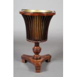 AN EARLY 19TH CENTURY MAHOGANY PEDESTAL ICE BUCKET the railed basket with brass liner, on a vase