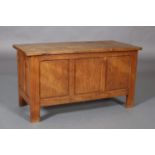 AN ADZED OAK BLANKET BOX with lift uplid above a triple indented panel front, conforming sides and